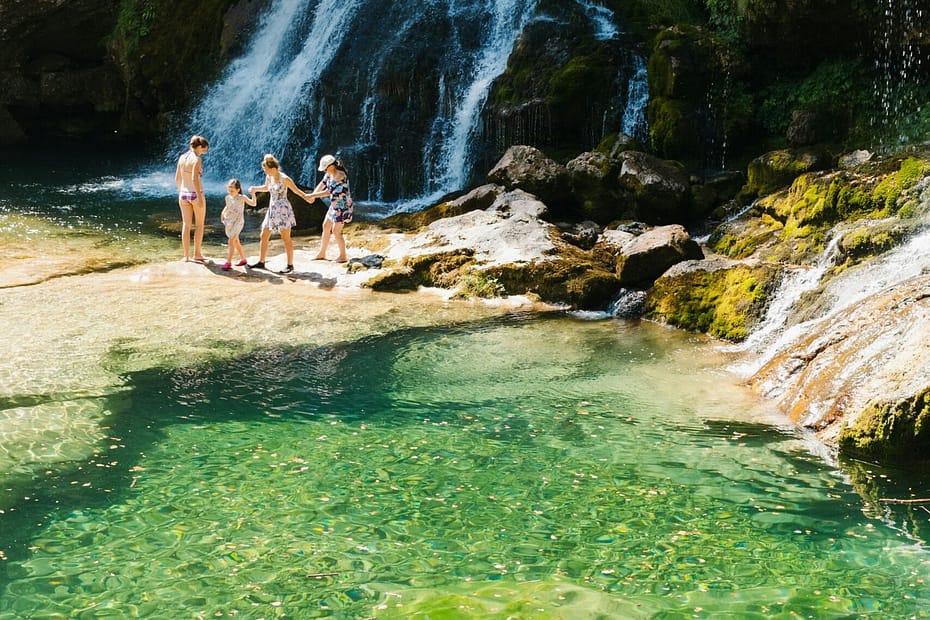 a group of people standing in front of a waterfall